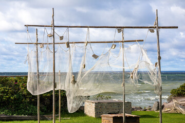 
The fishing net is drying on the seashore on wooden poles