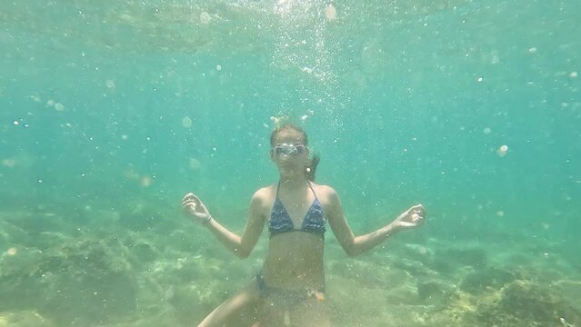 Undersea scene of girl in yoga pose. 