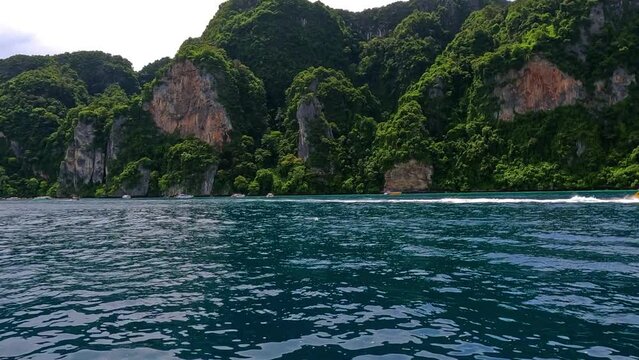 Phi Phi island off the coast of phuket thailand. Phi phi island is famous for turquoise clear blue waters teaming with Corel reef fish white soft sand and lush green trees.