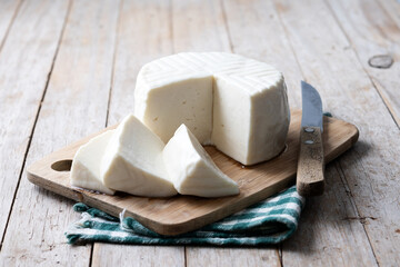 Sliced fresh white cheese from cow's milk on wooden table