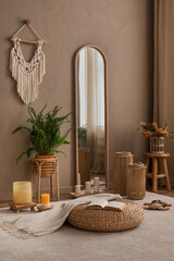 Creative composition of bedroom interior with stylish mirror, braided pouf, plaid, plants in...