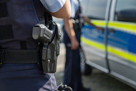 Polizisten bei Verhaftung am Streifenwagen