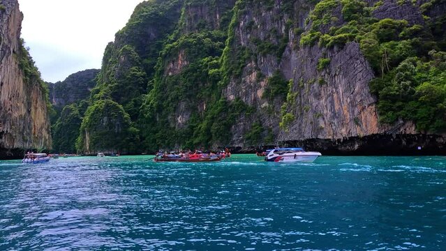 Phi Phi island off the coast of phuket thailand. Phi phi island is famous for turquoise clear blue waters teaming with Corel reef fish white soft sand and lush green trees.
