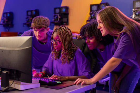 Photo of a concentrated team of professional Esport players playing a video game in a championship arena. The purple team intends to win. Cyber ​​Games online streaming tournament event.