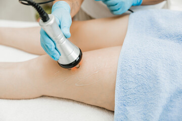 cosmetologist performing ultrasonic cavitation procedure on a client. a woman undergoes treatment...