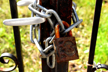 old rusty lock on closed gate entrance.padlock and chain