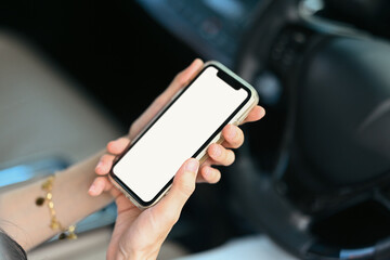 Young woman using mobile phone while driving car for navigation or searching destination on gps map