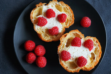 Cakes with raspberries on a black plate on a dark background