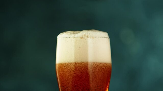 Super Slow Motion Detail Shot of Rippling Beer Bubbles and Foam in Glass at 1000fps.
