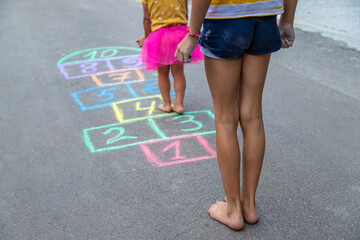 Children play hopscotch on the street. Selective focus.