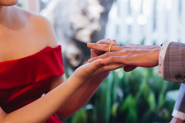 During a wedding, the bride and groom exchange wedding rings. Hand close-up