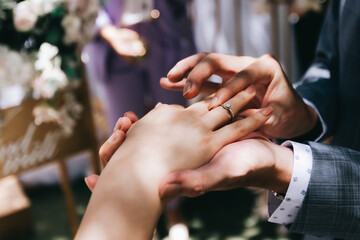 During a wedding, the bride and groom exchange wedding rings. Hand close-up