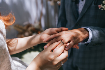 During a wedding, the bride and groom exchange wedding rings. Hand close-up