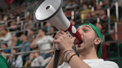 Loud man scream megaphone sport stadium. Crazy mad fan shout bullhorn close up. Insane male cheer...