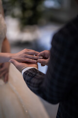 During a wedding, the bride and groom exchange wedding rings. Hand close-up