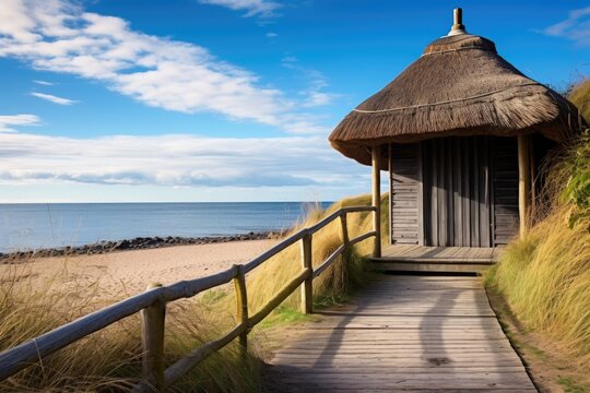 thatched beach hut with a wooden path to the water