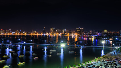 Fototapeta na wymiar Skyscrapers and Pattaya Bay in the night over lighting, Pattaya city is famous for sea sport and night life entertainment, Chonburi Province Thailand, Laem Bali Hai view point,