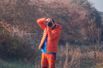 Man taking a photo while looking at camera