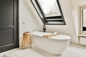 Modern bathroom with bathtub by large window