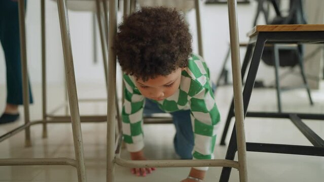 Happy kindergarten little boy enjoy playing on table in classroom at school. schoolboy enjoy play mischievously in classroom at school. Children and education concept