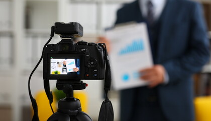 Male in suit and tie show stats graph pad making promo videoblog or photo session in office camcorder to tripod closeup. Vlogger selfie sale solution or finance advisor management information © H_Ko
