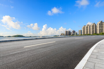 Asphalt road and residential area buildings scenery by the sea