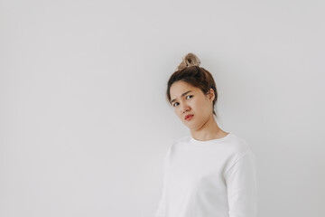 Asian Thai woman wear sweater bun hair, funny doubt and curious face, have question looking at camera, isolated on white background wall at winter.