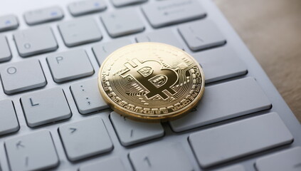 Coin crypto currency bitcoin lies on the keyboard background theme gold exchange pyramid for money due to rise or fall exchange rate closeup