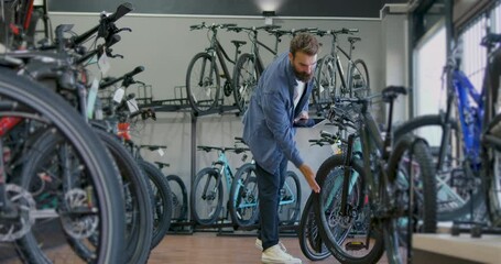 Male Small Business Owner Working in Bicycle Store using Digital tablet - Powered by Adobe