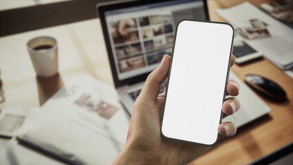 CU 30s Caucasian male using a phone near his work desk in the office, mock up