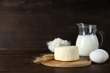 Dairy products on a wooden board, on a dark background.
