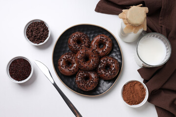 Preparation of chocolate donuts on a light background.
