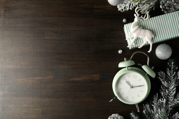 A clock with a New Year's decoration, on a dark background.