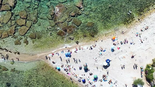 L'istmo di sabbia che collega Isola Bella e la spiaggia di Taormina. Il mare della Sicilia, Italia. 
Vista dall'alto dell'acqua trasparente e della spiaggia piena di bagnanti