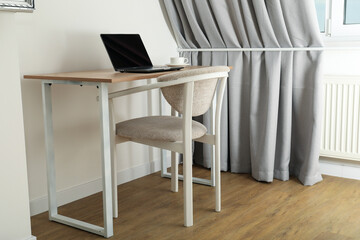 A cup of coffee and a laptop on the table