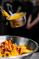 chef Cooking of crispy corn chips nachos at the restaurant kitchen