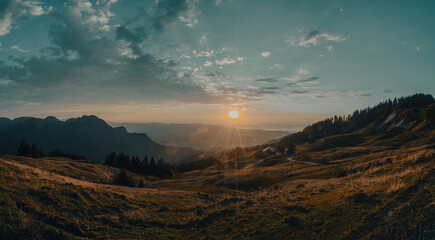 Warm sunset on a late summer evening in the Austrian mountains with view on Lake of Constance in the distance