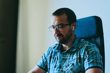Fototapeta premium Portrait professional man programmer working concentrated on computer in diverse offices. Modern IT technologies, development artificial intelligence, programs, applications and video games concept.
