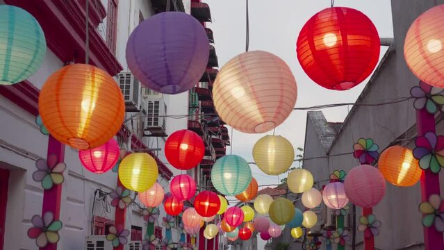 Narrow street is decorated with colorful pinwheels and lanterns