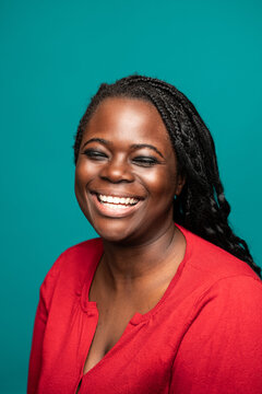 Warm smile of African woman against teal background