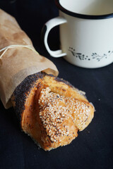 Puffs with poppy seeds and sesame seeds next to a cup of tea on a dark background