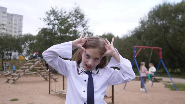 Portrait of a little girl grimaces and laughs outside