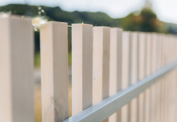 Wooden fence around a beautiful house. fence made of wooden slats. - obrazy, fototapety, plakaty