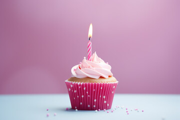 Birthday cupcake with burning candle on pink background, closeup