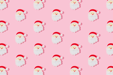 Head of Santa Claus with red hat on pastel pink background. Christmas pattern.
