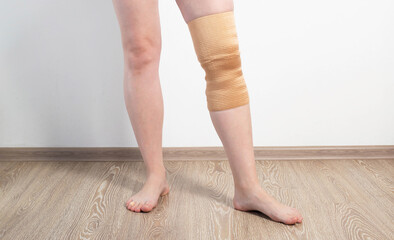 Orthopedic medical kneecap on the leg of a girl. Fixation and support of the knee joint after...