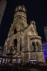 Fototapeta premium New Year's Eve night view of Kaiser Wilhelm Memorial Church with broken spire and New church and belfry on Breitscheidplatz. Berlin, Germany.