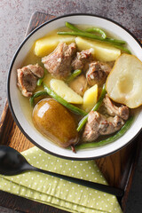 Homemade stew made from lamb meat, fresh pears, potatoes, green beans close-up in a bowl on a...