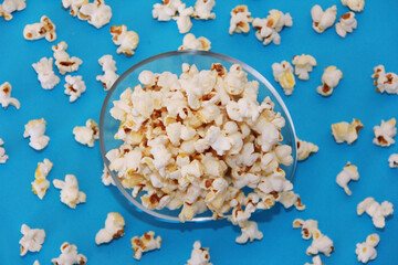 Delicious white airy fried popcorn in a plate on a blue background