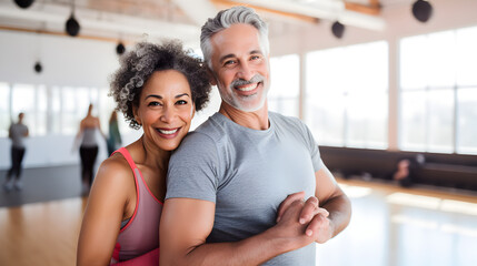 Happy senior mixed race couple standing together in a gym after exercising